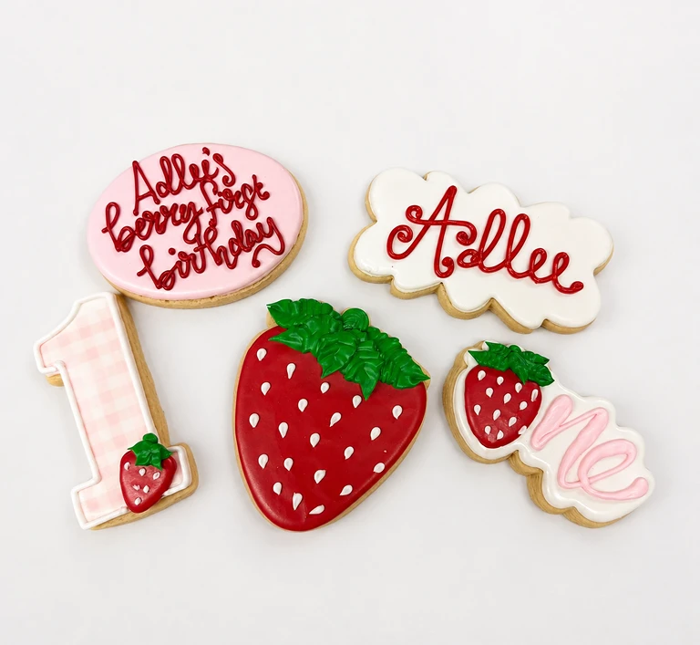 Strawberry-themed birthday cookies with personalized icing.